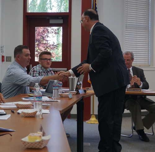 Dr. Giovanni Annous (standing, at right) shakes hands with Upper Lake Unified School District Board President Keith Austin as retiring Superintendent Patrick Iaccino (right) looks on following the board’s unanimous vote to confirm Annous’ contract as the next superintendent on Wednesday, May 10, 2017, in Upper Lake, Calif. Annous’ contract calls for him to officially assume the superintendent’s role as of Saturday, July 1, 2017. Photo by Elizabeth Larson/Lake County News. 051017giovanniannous2